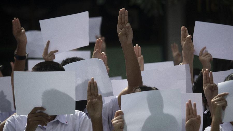 Pro-democracy students raise a three-fingers, symbol of resistance salute during a protest rally at Mahidol University in Nakhan Pathom, Thailand, Tuesday, Aug. 18, 2020.  Student protesters have stepped up pressure on the government with three core demands: holding new elections, amending the constitution and ending the intimidation of critics of the government. (AP Photo/Gemunu Amarasinghe)