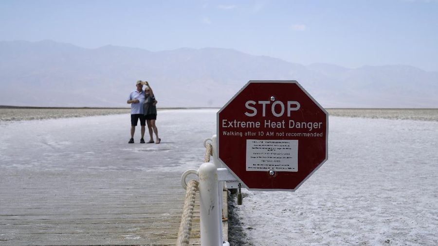 A person walks on a boardwalk at the salt flats at Badwater Basin, Monday, Aug. 17, 2020, in Death Valley National Park, Calif. Death Valley recorded a scorching 130 degrees (54.4 degrees Celsius) Sunday, which if the sensors and other conditions check out, would be the hottest Earth has been in more than 89 years and the third-warmest ever measured. (AP Photo/John Locher)