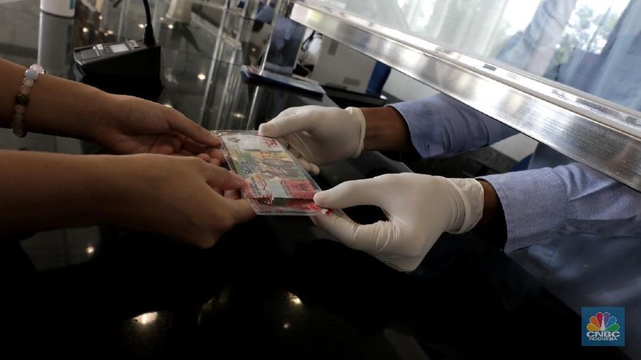 Warga menunjukkan uang baru 75.000 Ribu di Gedung BI. (CNBC Indonesia/Muhammad Sabki)
