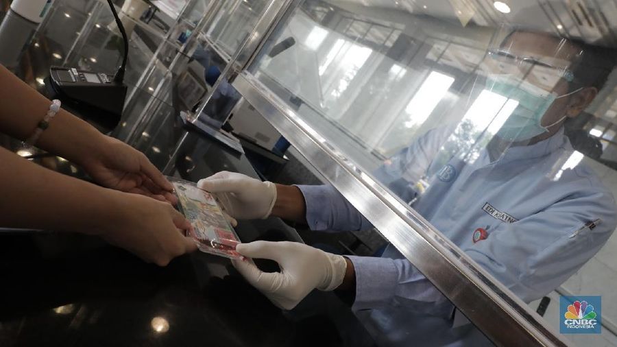 Warga menunjukkan uang baru 75.000 Ribu di Gedung BI. (CNBC Indonesia/Muhammad Sabki)