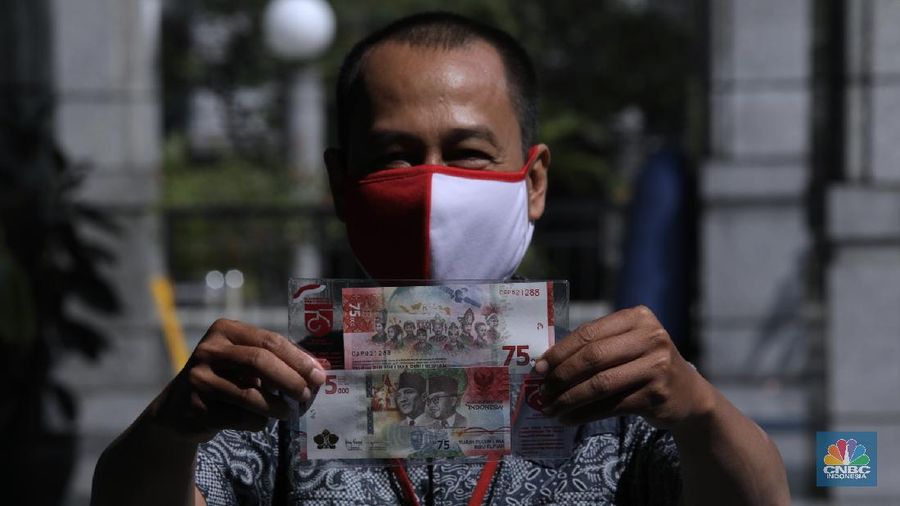 Warga menunjukkan uang baru 75.000 Ribu di Gedung BI. (CNBC Indonesia/Muhammad Sabki)