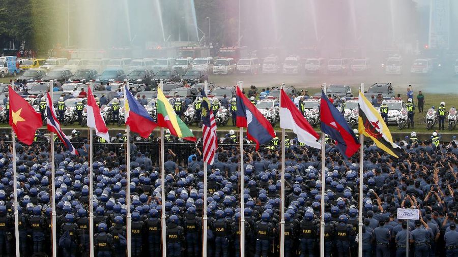 Thousands of police and soldiers watch the unveiling of the summit logo during a send off ceremony and deployment to provide security for next week's ASEAN Summit and other related summits which the country is hosting in Manila, Philippines Sunday, Nov. 5, 2017. ASEAN leaders and its Dialogue Partners such as the United States, Russia, China, Japan, South Korea, India, Turkey, Australia, Canada, New Zealand, the European Council and U.N. Secretary General Antonio Guterres are attending the summit. (AP Photo/Bullit Marquez)