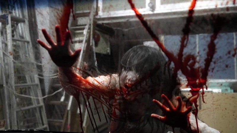 Casts as zombies perform by the window of a vehicle during a demonstration of a drive-in haunted house show at a garage Tuesday, Aug. 18, 2020, in Tokyo. Visitors remain in vehicles as taking prevention measures against the COVID-19 pandemic, while ghosts, zombies and other characters spook the visitors. Visitors could experience the entertainment with the safety of being inside their own vehicles. Or, a vehicle provided by the program is also available for rent at the site. (AP Photo/Eugene Hoshiko)