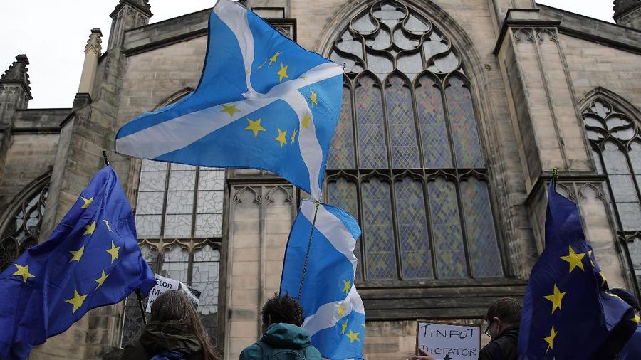 Protesters holding Scottish and European flags gather in front of St Gilles Cathedral facing the Scottish Court of Session in Edinburgh, Scotland, Wednesday, Sept 4, 2019. A Scottish court says British Prime Minister Boris Johnson's planned suspension of Parliament is lawful. The closely watched decision was revealed Wednesday. It is the first of several challenges to Johnson's maneuver that gives lawmakers little time to prevent Britain from crashing out of the European Union without an agreement on Oct. 31. (AP Photo/Francois Mori)