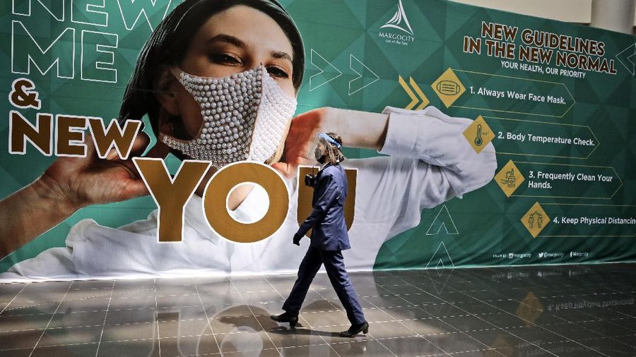Indonesian firemen spray disinfectant to help curb the spread of the new coronavirus outbreak at Margo City shopping mall, which has been closed after a number of employees of a supermarket at the mall were tested positive for the virus, in Depok, Indonesia, Saturday, Aug. 22, 2020. (AP Photo/Dita Alangkara)