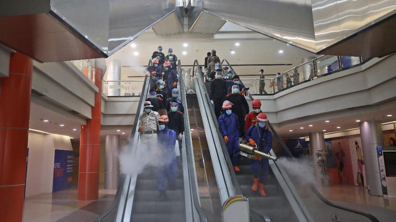 Indonesian firemen spray disinfectant to help curb the spread of the new coronavirus outbreak at Margo City shopping mall, which has been closed after a number of employees of a supermarket at the mall were tested positive for the virus, in Depok, Indonesia, Saturday, Aug. 22, 2020. (AP Photo/Dita Alangkara)