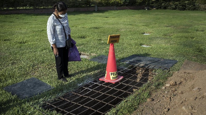 A Catholic priest prays during the burial of TV news cameraman Mario Bucana, who died of COVID-19, at a cemetery in Lima, Peru, Thursday, May 28, 2020. Dozens of journalists have died from COVID-19 in Peru since the pandemic began, in the highest reported death toll of media workers from the new coronavirus in any Latin American country, according to journalists’ groups that are monitoring available data. (AP Photo/Rodrigo Abd)