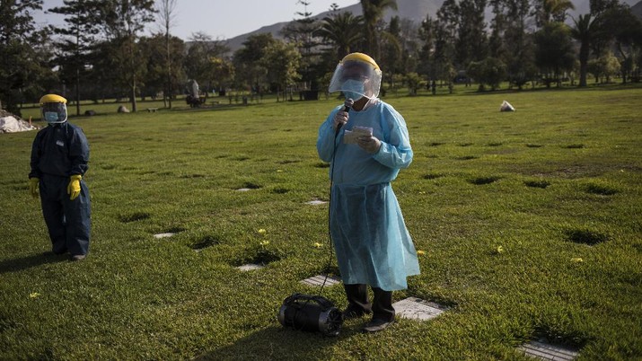 Virus Outbreak Peru Journalists A Catholic priest prays during the burial of TV news cameraman Mario Bucana, who died of COVID-19, at a cemetery in Lima, Peru, Thursday, May 28, 2020. Dozens of journalists have died from COVID-19 in Peru since the pandemic began, in the highest reported death toll of media workers from the new coronavirus in any Latin American country, according to journalists’ groups that are monitoring available data. (AP Photo/Rodrigo Abd)