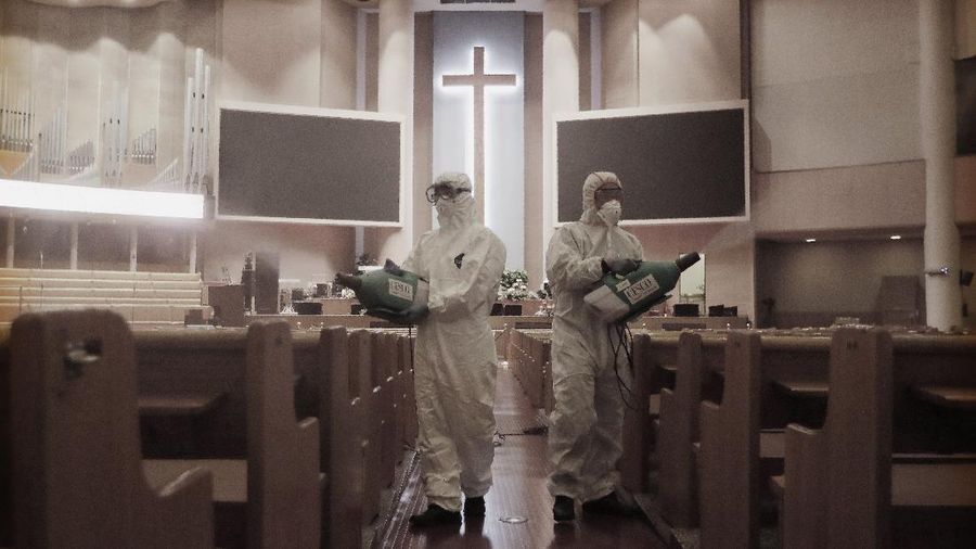 Public officials disinfect pews as a precaution against the coronavirus at the Yoido Full Gospel Church in Seoul, South Korea, Friday, Aug. 21, 2020. South Korea's Centers for Disease Control and Prevention on Friday reported new infections from practically all major cities nationwide, including Busan, Gwangju, Daejeon, Sejong and Daegu, a southeastern city that was the epicenter of a massive outbreak in late February and March. (AP Photo/Ahn Young-joon)