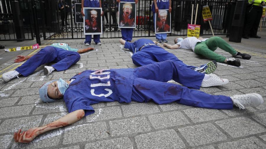 Anggota perawat dan staf Layanan Kesehatan Nasional Inggris (NHS) melakukan aksi di tengah penyebaran penyakit COVID-19, di luar Downing Street di London, Inggris. (AP/Kirsty Wigglesworth)