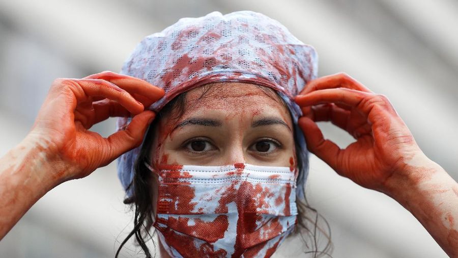 Anggota perawat dan staf Layanan Kesehatan Nasional Inggris (NHS) melakukan aksi di tengah penyebaran penyakit COVID-19, di luar Downing Street di London, Inggris. (AP/Kirsty Wigglesworth)