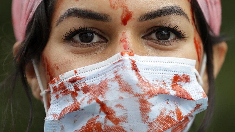 Anggota perawat dan staf Layanan Kesehatan Nasional Inggris (NHS) melakukan aksi di tengah penyebaran penyakit COVID-19, di luar Downing Street di London, Inggris. (AP/Kirsty Wigglesworth)