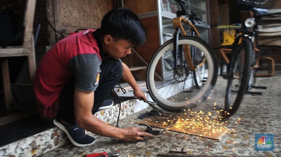 Sejumlah pekerja mengerjakan proses pembuatan sepeda kayu di Tapos, Depok, Jawa Barat. (CNBC Indonesia/Muhammad Sabki)