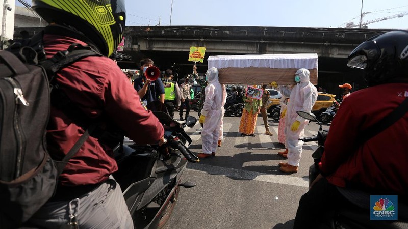 Petugas gabungan dari Kecamatan Cilandak dan Polsek Cilandak mengarak instalasi peti mati jenazah Covid-19 saat melakukan sosialisasi bahaya virus Covid-19 di kawasan Fatmawati, Jakarta. (CNBC Indonesia/Andrean Kristianto)