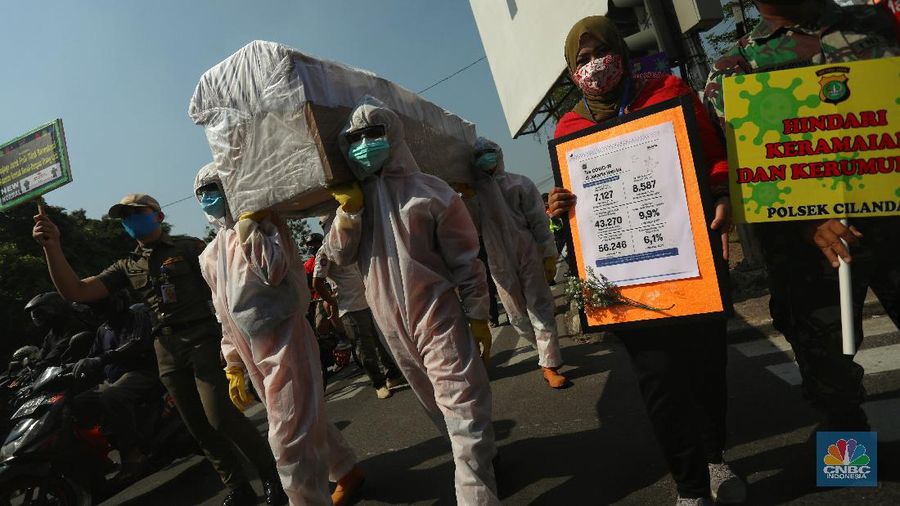 Petugas gabungan dari Kecamatan Cilandak dan Polsek Cilandak mengarak instalasi peti mati jenazah Covid-19 saat melakukan sosialisasi bahaya virus Covid-19 di kawasan Fatmawati, Jakarta. (CNBC Indonesia/Andrean Kristianto)