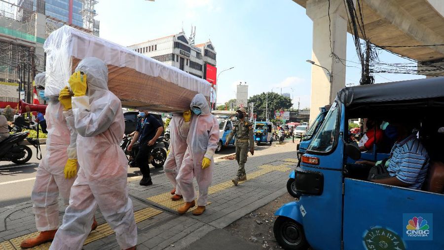 Petugas gabungan dari Kecamatan Cilandak dan Polsek Cilandak mengarak instalasi peti mati jenazah Covid-19 saat melakukan sosialisasi bahaya virus Covid-19 di kawasan Fatmawati, Jakarta. (CNBC Indonesia/Andrean Kristianto)