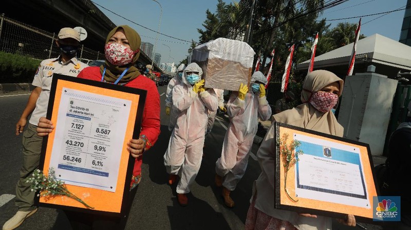 Petugas gabungan dari Kecamatan Cilandak dan Polsek Cilandak mengarak instalasi peti mati jenazah Covid-19 saat melakukan sosialisasi bahaya virus Covid-19 di kawasan Fatmawati, Jakarta. (CNBC Indonesia/Andrean Kristianto)