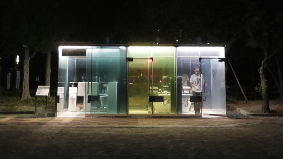 A man gets out of one of the transparent glass toilets after use at Yoyogi Hukamachi Mini Park in Tokyo on Thursday, Aug. 20, 2020. The bathrooms with the tinted wall turn opaque when it's in use. The walls of two newly installed public toilets in Tokyo's Shibuya neighborhood are see-through before people enter, but turn opaque when the doors are closed and locked from the inside. The so-called transparent toilets, which opened this month, were designed by award-winning Japanese architect Shigeru Ban for a project organized by The Nippon Foundation that redesigned a total of 17 public toilets in the neighborhood. (AP Photo/Hiro Komae)