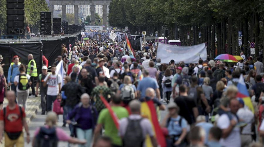 People attend a protest rally in Berlin, Germany, Saturday, Aug. 29, 2020 against new coronavirus restrictions in Germany. Police in Berlin have requested thousands of reinforcements from other parts of Germany to cope with planned protests at the weekend by people opposed to coronavirus restrictions. (AP Photo/Michael Sohn)