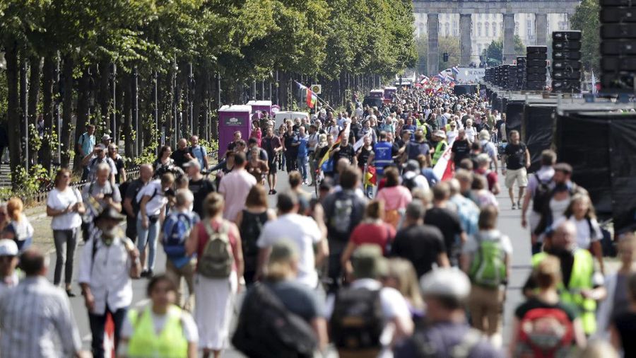 People attend a protest rally in Berlin, Germany, Saturday, Aug. 29, 2020 against new coronavirus restrictions in Germany. Police in Berlin have requested thousands of reinforcements from other parts of Germany to cope with planned protests at the weekend by people opposed to coronavirus restrictions. (AP Photo/Michael Sohn)