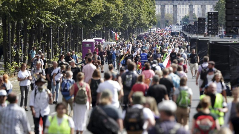 People attend a protest rally in Berlin, Germany, Saturday, Aug. 29, 2020 against new coronavirus restrictions in Germany. Police in Berlin have requested thousands of reinforcements from other parts of Germany to cope with planned protests at the weekend by people opposed to coronavirus restrictions. (AP Photo/Michael Sohn)
