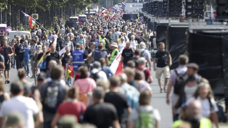 People attend a protest rally in Berlin, Germany, Saturday, Aug. 29, 2020 against new coronavirus restrictions in Germany. Police in Berlin have requested thousands of reinforcements from other parts of Germany to cope with planned protests at the weekend by people opposed to coronavirus restrictions. (AP Photo/Michael Sohn)