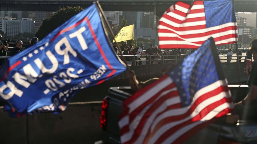 Pendukung Presiden Donald Trump menghadiri rapat umum dengan mengendari parade mobil. (AP/Dave Killen)