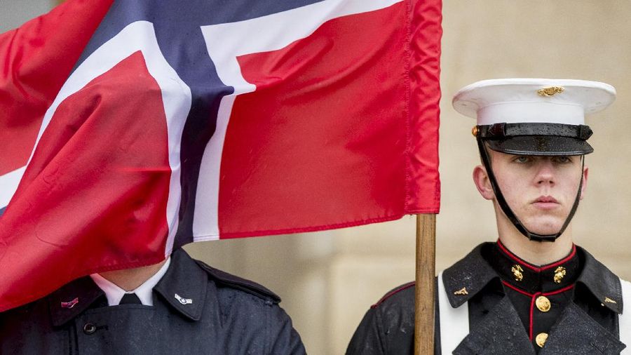 A Norwegian flag flies in the face of a member of a the military during a ceremony to welcome Norwegian Defense Minister Frank Bakke-Jensen to the Pentagon in Washington, Tuesday, March 20, 2018. (AP Photo/Andrew Harnik)