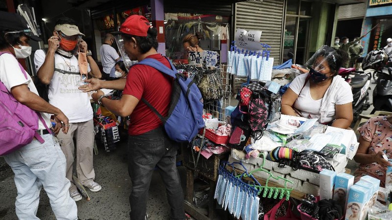 Men buy face masks to help curb the spread of the COVID-19 in Caloocan city, Philippines on Wednesday, Aug. 19, 2020. Philippine President Rodrigo Duterte has decided to ease a mild coronavirus lockdown in the capital and four outlying provinces to further reopen the country's battered economy despite having the most reported infections in Southeast Asia. (AP Photo/Aaron Favila)