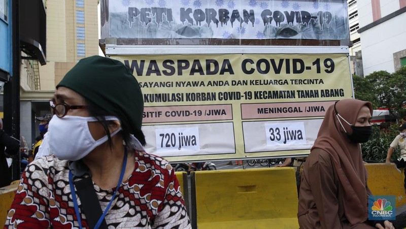 Beberapa warga sedang menunggu angkutan umum dengan latar belakang replika peti mati dan papan imbauan waspada Covid-19 di kawasan Pasar Tanah Abang, Jakarta, Selasa (1/9/2020). (CNBC Indonesia/Tri Susilo)

Instalasi replika peti mati dan papan imbauan waspada COVID-19 di sejumlah lokasi dimana DKI Jakarta masih menjadi wilayah tertinggi penyebaran. Hingga 1 September 2020 kasus terkonfirmasi COVID-19 nasional telah mencapai 177.571 kasus. Jumlah kasus positif di Jakarta 40.987, bertambah 901 per hari ini (1/9/2020).   

Masih banyak warga yang kurang sadar pentingnya menggunakan masker, dan jaga jarak diruang publik.  (CNBC Indonesia/ Tri Susilo)
