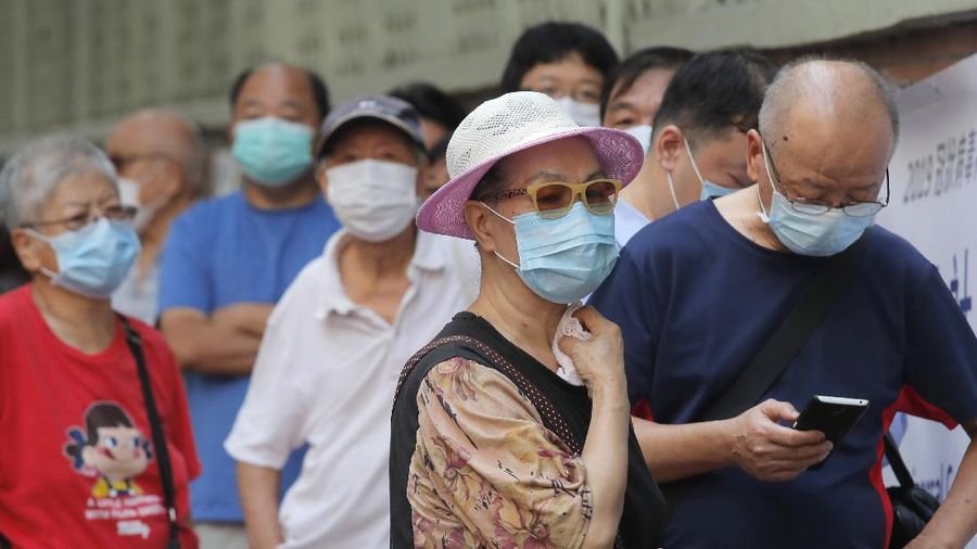 People wearing face masks queue for the coronavirus test outside a testing center in Hong Kong, Tuesday, Sept. 1, 2020. Hong Kong began a voluntary mass-testing program for coronavirus Tuesday as part of a strategy to break the chain of transmission in the city's third outbreak of the disease. The virus-testing program has become a flash point of political debate in Hong Kong, with many distrustful over resources and staff being provided by the China's central government and fears that the residents’ DNA could be collected during the exercise.(AP Photo/Kin Cheung)