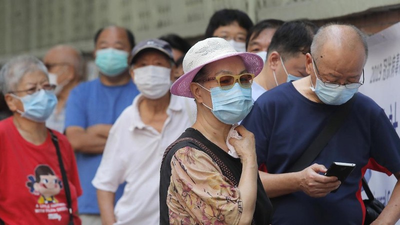 People wearing face masks queue for the coronavirus test outside a testing center in Hong Kong, Tuesday, Sept. 1, 2020. Hong Kong began a voluntary mass-testing program for coronavirus Tuesday as part of a strategy to break the chain of transmission in the city's third outbreak of the disease. The virus-testing program has become a flash point of political debate in Hong Kong, with many distrustful over resources and staff being provided by the China's central government and fears that the residents’ DNA could be collected during the exercise.(AP Photo/Kin Cheung)