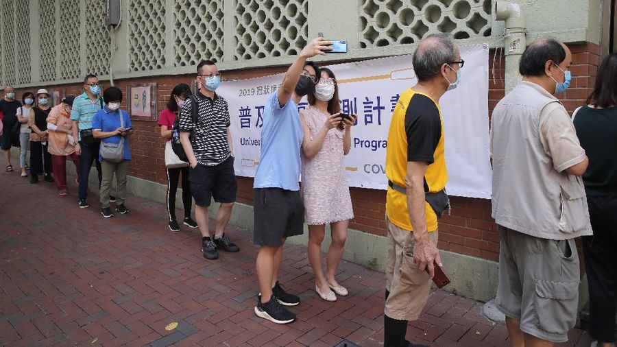 People wearing face masks queue for the coronavirus test outside a testing center in Hong Kong, Tuesday, Sept. 1, 2020. Hong Kong began a voluntary mass-testing program for coronavirus Tuesday as part of a strategy to break the chain of transmission in the city's third outbreak of the disease. The virus-testing program has become a flash point of political debate in Hong Kong, with many distrustful over resources and staff being provided by the China's central government and fears that the residents’ DNA could be collected during the exercise.(AP Photo/Kin Cheung)