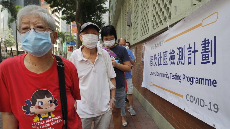 People wearing face masks queue for the coronavirus test outside a testing center in Hong Kong, Tuesday, Sept. 1, 2020. Hong Kong began a voluntary mass-testing program for coronavirus Tuesday as part of a strategy to break the chain of transmission in the city's third outbreak of the disease. The virus-testing program has become a flash point of political debate in Hong Kong, with many distrustful over resources and staff being provided by the China's central government and fears that the residents’ DNA could be collected during the exercise.(AP Photo/Kin Cheung)