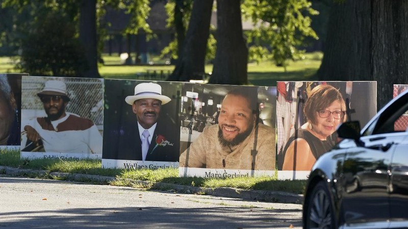 Some of the nearly 900 large poster-sized photos of Detroit victims of COVID-19 are displayed, Monday, Aug. 31, 2020 on Belle Isle in Detroit. Families have a chance to take one last public look at their lost loved ones in the nation's first citywide memorial to honor victims of the pandemic. Mourners will join 14 consecutive funeral processions to drive past the photos of their loved ones staked around the island. (AP Photo/Carlos Osorio)