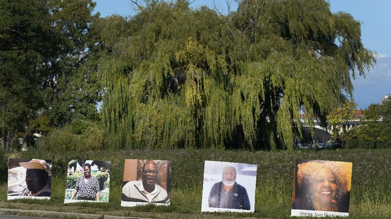 Some of the nearly 900 large poster-sized photos of Detroit victims of COVID-19 are displayed, Monday, Aug. 31, 2020 on Belle Isle in Detroit. Families have a chance to take one last public look at their lost loved ones in the nation's first citywide memorial to honor victims of the pandemic. Mourners will join 14 consecutive funeral processions to drive past the photos of their loved ones staked around the island. (AP Photo/Carlos Osorio)