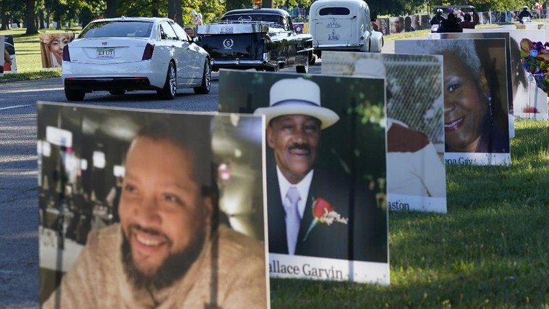 Some of the nearly 900 large poster-sized photos of Detroit victims of COVID-19 are displayed, Monday, Aug. 31, 2020 on Belle Isle in Detroit. Families have a chance to take one last public look at their lost loved ones in the nation's first citywide memorial to honor victims of the pandemic. Mourners will join 14 consecutive funeral processions to drive past the photos of their loved ones staked around the island. (AP Photo/Carlos Osorio)