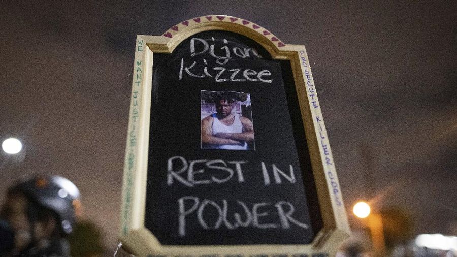 A protester holds a sign with a picture of Dijon Kizzee, who died after being shot by deputies of the Los Angeles Sheriff's Department on Monday, Aug. 31, 2020, in Los Angeles, Calif. (AP Photo/Christian Monterrosa)