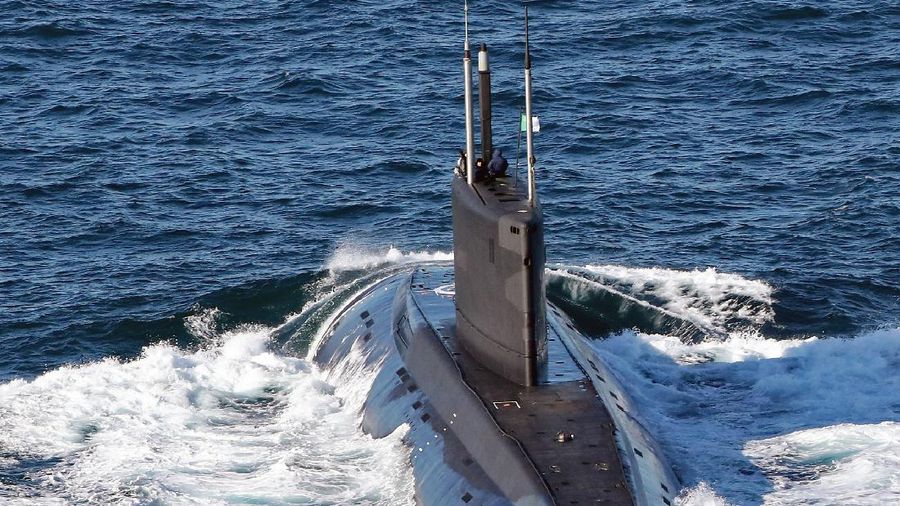Pictured is a Kilo-Class Russian Submarine in the English Channel.

The image was taken from Royal Navy Wildcat HMA2 Helicopter of 815 Naval Air Squadron.

Kilo class is the NATO reporting name for the diesel-electric attack submarine.

The original vessels were designated Project 877 EKM Paltus (Halibut) in the Soviet Union and entered service in 1980s.

There is also a more advanced version, designated as Improved Kilo-class submarine in the West, and Project 636 Varshavyanka in Russia.

These attack submarines are mainly intended for anti-shipping and anti-submarine operations in relatively shallow waters. 

The subs are armed with 18 heavyweight torpedoes and 8 surface to air missiles (NATO name Gremlin & Gimlet) 

Newer boats are equipped with improved sonar and mine detection. The improved sonar systems have reduced the number of operators needed because of increased automation.

Anechoic (free from echo) tiles are fitted to absorb the sound waves of active sonar, which results in a reduction and distortion of the return signal.

These tiles also help reduce sounds emitted from the submarine, reducing the range at which the sub may be detected.

There are around 24 Kilo Class Submarines currently in service with the Russian Navy (mostly the 877 boats).