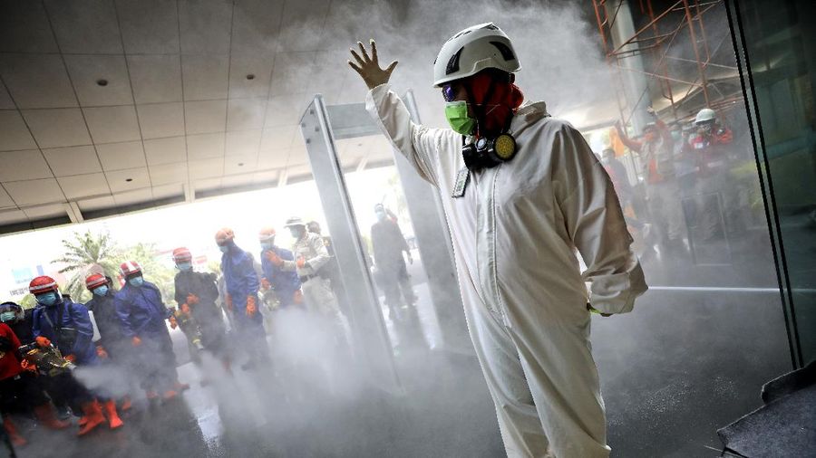 A team leader makes a hand signal as Indonesian firemen test their equipment prior to disinfecting Margo City shopping mall to help curb the spread of the new coronavirus outbreak, after a number of employees of a supermarket at the mall were tested positive for the virus, in Depok, Indonesia, Saturday, Aug. 22, 2020. (AP Photo/Dita Alangkara)