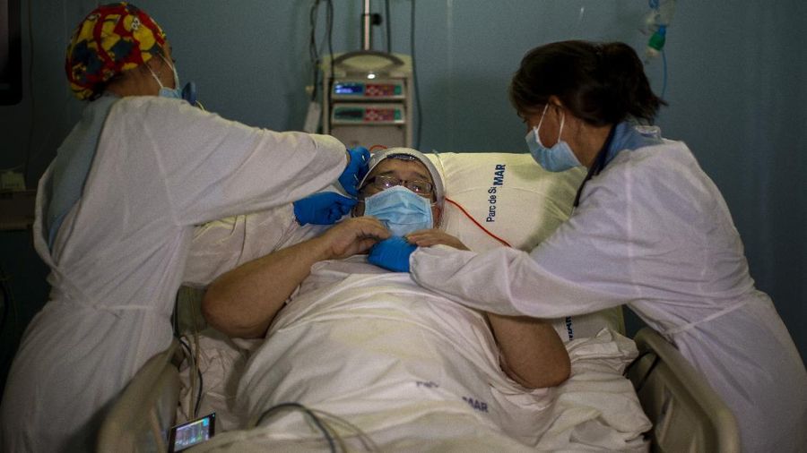 Members of the medical staff make preparations for Francisco España, 60, to be taken out by the sea, at the