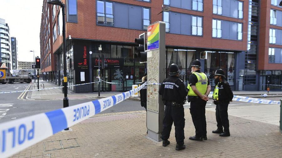 A police forensics officer taking photographs in Irving Street, in Birmingham after a number of people were stabbed in the city centre, Sunday, Sept. 6, 2020. British police say that multiple people have been injured in a series of stabbings in a busy nightlife area of the central England city of Birmingham.(Jacob King/PA via AP)