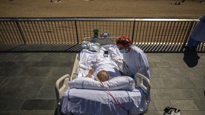 Members of the medical staff make preparations for Francisco España, 60, to be taken out by the sea, at the 
