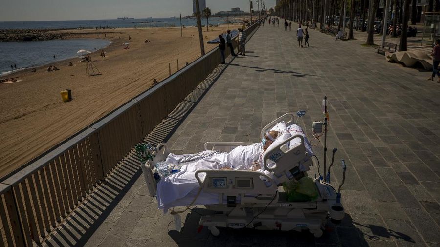 Members of the medical staff make preparations for Francisco España, 60, to be taken out by the sea, at the 