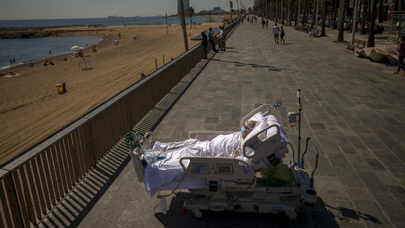 Members of the medical staff make preparations for Francisco España, 60, to be taken out by the sea, at the 
