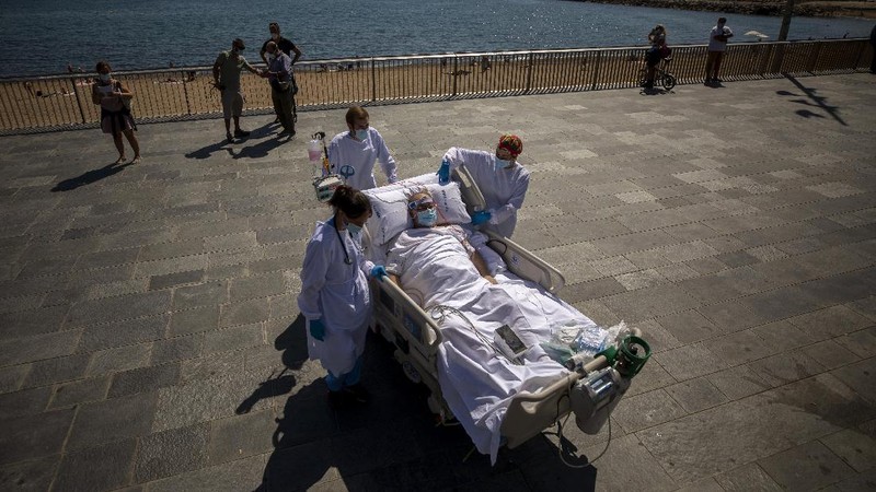Members of the medical staff make preparations for Francisco España, 60, to be taken out by the sea, at the 