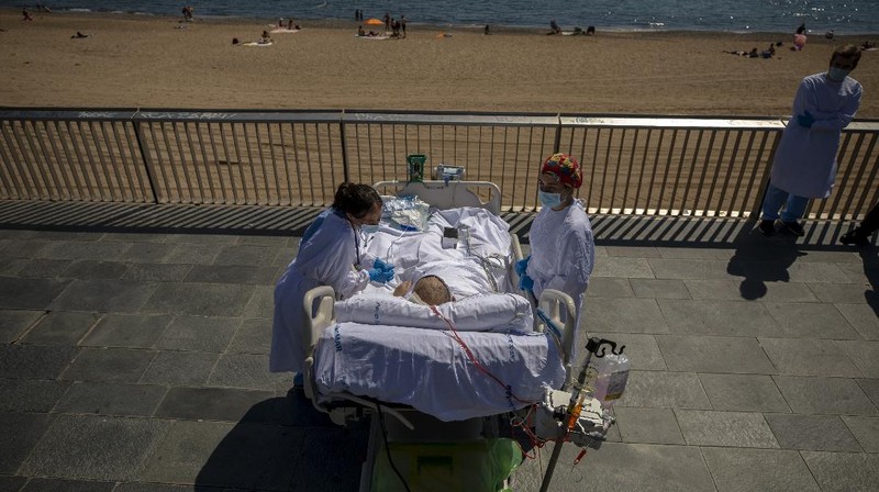 Members of the medical staff make preparations for Francisco España, 60, to be taken out by the sea, at the 