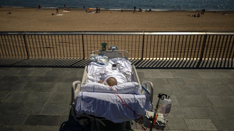 Members of the medical staff make preparations for Francisco España, 60, to be taken out by the sea, at the 