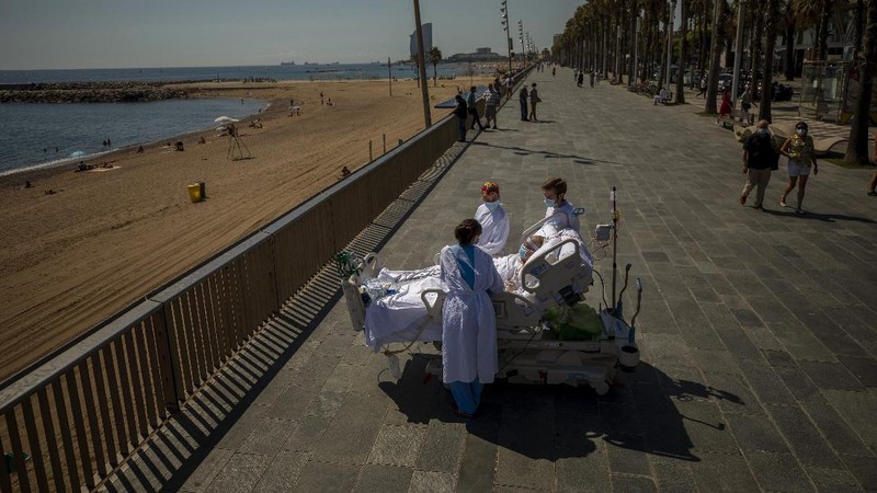 Members of the medical staff make preparations for Francisco España, 60, to be taken out by the sea, at the 