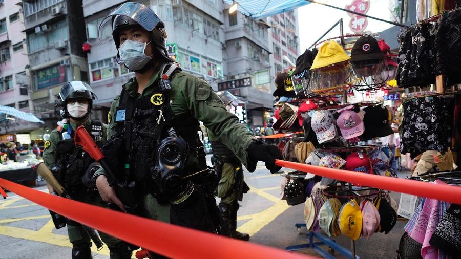 FILE - In this Wednesday, July 1, 2020, file photo, police detain a protester after being pepper sprayed during a protest in Causeway Bay before the annual handover march to mark the 23rd anniversary of Hong Kong's handover to China in 1997. Seven human rights experts affiliated with the U.N. raised concerns over Hong Kong's national security law in a letter addressed to Chinese authorities, saying that the law infringed on certain fundamental rights. (AP Photo/Vincent Yu, file)